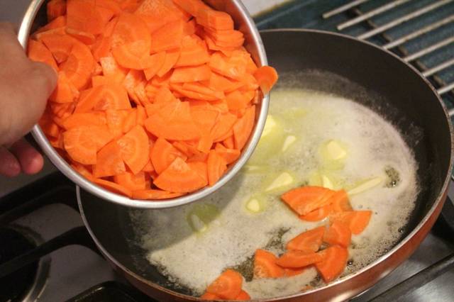 紅蘿蔔切片後，在平底鍋放入奶油，以中火加熱，在奶油還沒全部融化之前倒入紅蘿蔔片，讓紅蘿蔔片都沾上奶油後，加入1/4小匙的鹽，繼續拌炒。