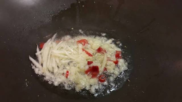 熱油後，放入蒜末、嫩薑絲及辣椒爆香，並炒出香氣。