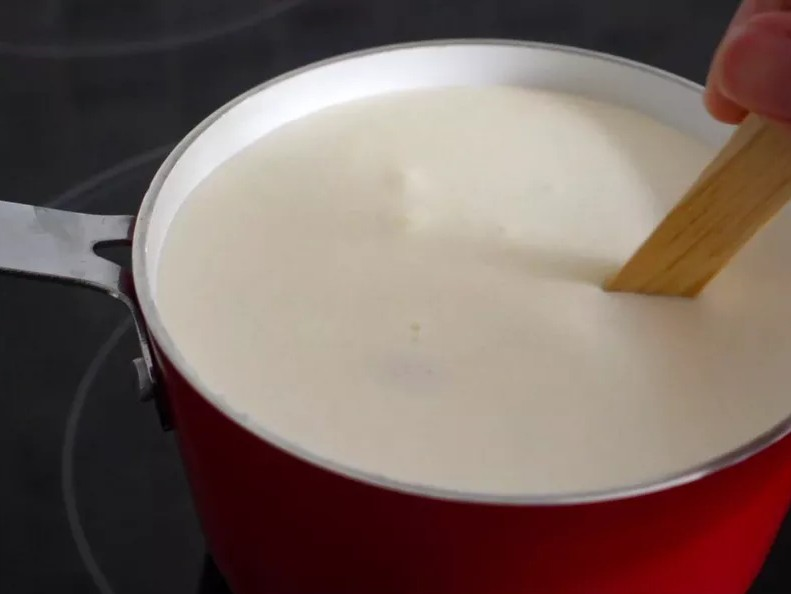 將鮮奶油、牛奶、砂糖、天然香草精全部加入鍋中，慢慢攪拌，並以中火煮至溫熱，直到糖完全溶解，不用煮到滾。