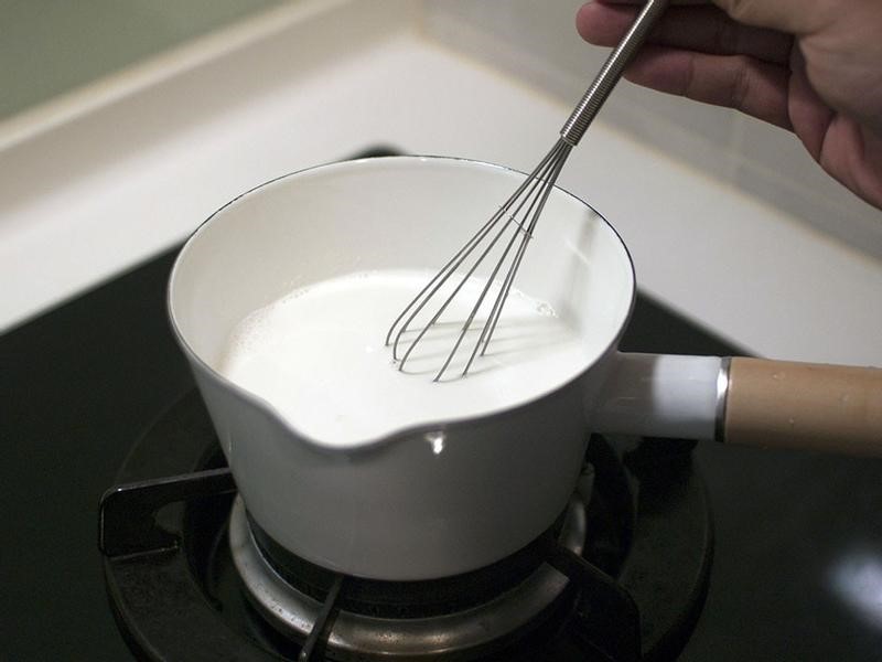 取出吉利丁片，擰乾後，放入溫羊奶中攪拌均勻。